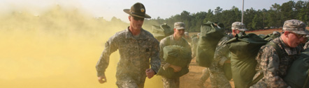 photo of several National Guard members running through a dusty landscape