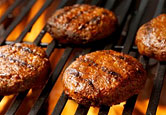 Burgers are cooked on the grill.