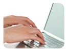 Image of hands typing on a laptop