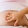 Photo: A child touching an expecting mother's belly