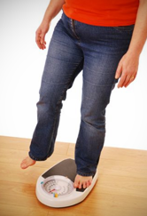 Woman balances one foot on the scale.