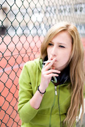 A teenage girl smokes.