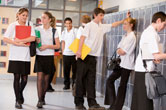 Students, dressed in similar clothes, hang out by their lockers.