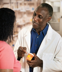 Pharmacist talking to patient with prescription