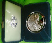 Image shows a silver bullion proof coin in a hinged and padded case.