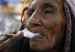 Sajadi, a ninety-year-old woman labourer, smokes a 'bidi' (an Indian leaf cigarette) at a roadside on the outskirts of New Delhi October 12, 2010. REUTERS/Parivartan Sharma