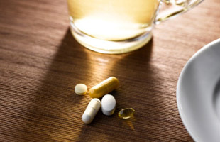 Image of dietary supplements and a glass of water