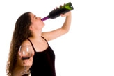 Young woman drinking wine from a bottle