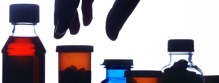 Image of a hand reaching for a pill bottle in a medicine cabinet