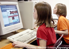 A photograph of children working at computers