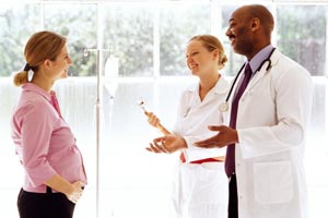 una mujer embarazada de hablar con un médico y una enfermera