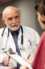 Photograph of a male doctor consulting with a female nurse