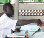 Man giving tuberculosis drugs at clinic in Cotonou, Benin