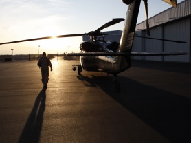 A CBP pilot approaches a helicopter