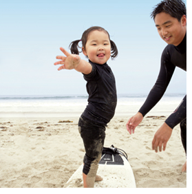 a dad teaching surfing to his daughter