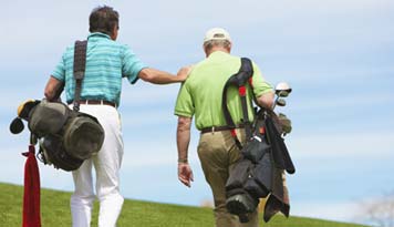 Photo of two men carrying their golf bags and walking on the golf course