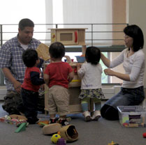 two adults and three children play together at the Berkeley Public Library