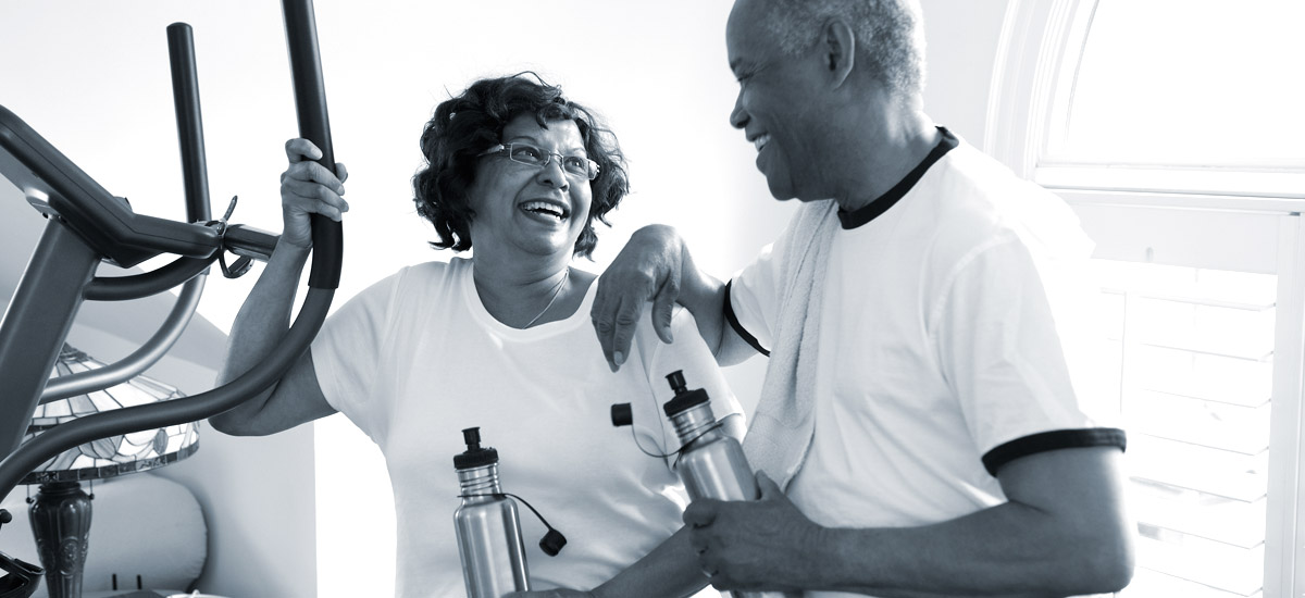 Photo of a man and woman in gym standing next to exercise machine