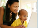 Photo of a mother with her young son looking at a computer