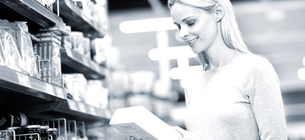 Photo of a woman holding box in grocery store aisle