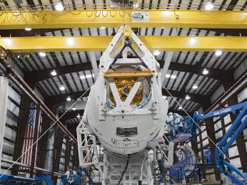 Technicians attach the Dragon capsule to a Falcon 9 rocket at the SpaceX facility at Cape Canaveral Air Force Station, Fla., during preparations for the CRS-1 mission.