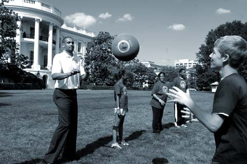 Image of Grant Hall tossing a ball with kids on the front lawn of the White House