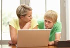 A mother and son look at a computer