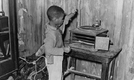 Child playing phonograph in cabin home