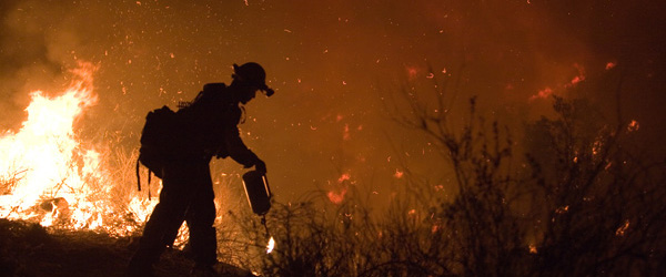 A smoke-jumper fighting a forest fire.