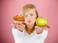 image of a lady holding a muffin and an apple