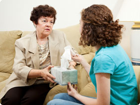 Older Woman Giving Younger Woman Box of Tissues