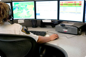 Security Officer Sitting Behind Three Computer Screens