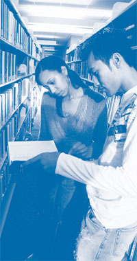 Young man and woman are reading a book in the library.