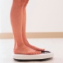 A woman's legs and feet on a scale.