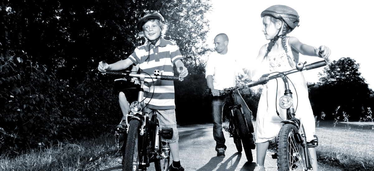 Photo of a young boy, girl and father riding bikes