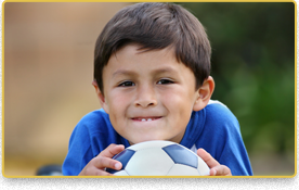 Un niño está acostado boca abajo sosteniendo un balón