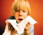 A photograph of a boy sneezing