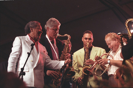 Image description: President Bill Clinton playing the saxophone at the 14th Anniversary of the Newport Jazz Festival in June, 1993.
Photo from the National Archives.