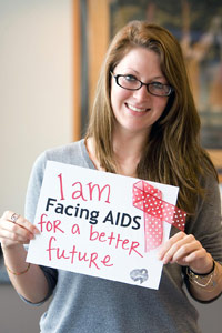 Woman smiling hold sign that says 'I am facing AIDS for a better future