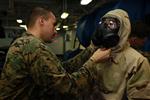 Lance Cpl. Anthony C. Bocz, assessment consequence management team member, Chemical, Biological, Radiological and Nuclear Defense Platoon, 15th Marine Expeditionary Unit, adjusts the M50 field protective mask on a Marine from Weapons Company, Battalion Landing Team 3/5, 15th MEU, during a class on CBRN defense aboard the USS Peleliu, Oct. 4. The 15th MEU's CBRN Defense Platoon is spending an entire month preparing the 2,400 servicemembers that make up the MEU on how to properly operate in contaminated environments. The 15th MEU is currently embarked as part of the Peleliu Amphibious Ready Group, while they serve as the nation's rapid-response sea-based Marine Air Ground Task Force for Western Pacific Deployment 12-02. Bocz, 20, is from Sacramento, Calif.
