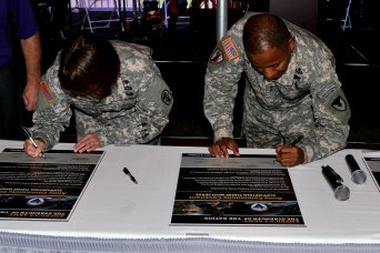 Maj. Gen. Robert S. Ferrell, Commander, U.S. Army Communications-Electronics Command (CECOM), and Senior Mission Command of Aberdeen Proving Ground, and Maj. Gen. Jimmie O. Keenan, Commander of the U.S. Army Public Health Command, sign the Army Community Covenant reaffirming APGs commitment to the communities surround the installation.