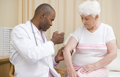 photo of senior woman getting vaccinated at doctor's office