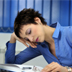 Photo of a woman nodding off at her desk.