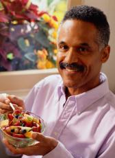 Photograph of a man eating a fruit salad