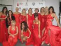 11 Argentinean celebrity women wearing designer red dresses posing after the Argentinean Red Dress Collection Fashion Show. Two women are kneeling and the rest are standing behind them. The image also includes Dr. Cristina Rabadan-Deihl