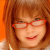Photo of a young girl reading with glasses.