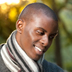 Photo of a young African-American man looking at a computer and smiling.