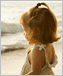 a photo of a little girl standing by the ocean