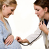 Photo of a pregnant woman being examined by a female doctor.