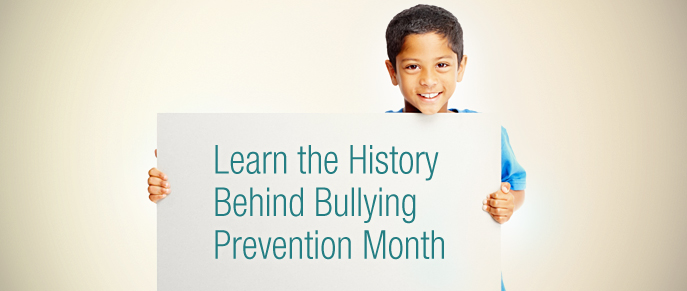 Boy holds sign on history of bullying prevention month